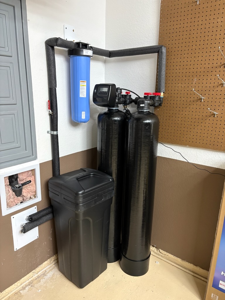 Blue filter housing with two black treatment tanks and a brine tank